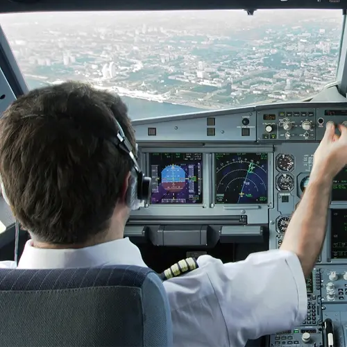 Airline pilot adjusting cockpit controls in flight — Emerald Coast Interview Consulting case study